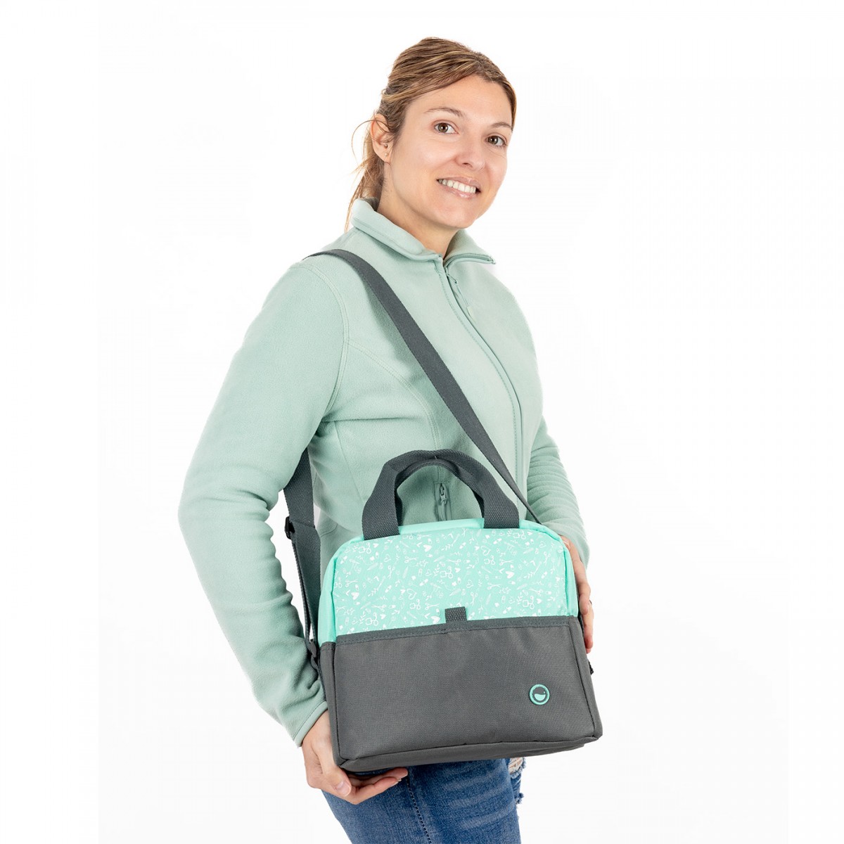 Mujer con un bolso de enfermera gris y menta con estampado de herramientas, diseñado para profesionales de la salud que necesitan un bolso de mano duradero y organizado para el trabajo.