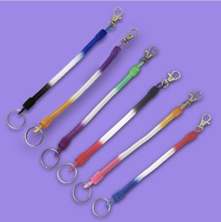 Varios llaveros en espiral para trabajadores sanitarios en varios colores, cada uno con un clip para sujetarlo fácilmente a las batas médicas. Son perfectos para mantener las llaves seguras y a mano.