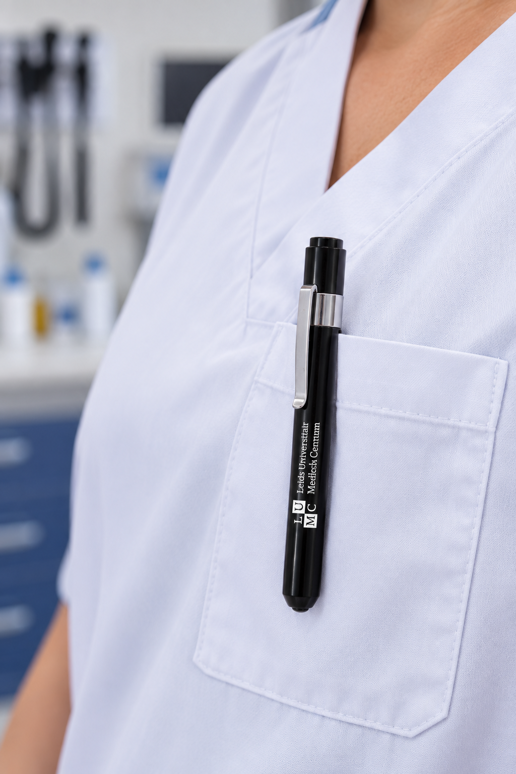 Black pen in the pocket of a light blue medical uniform, ideal for healthcare workers and note-taking.
