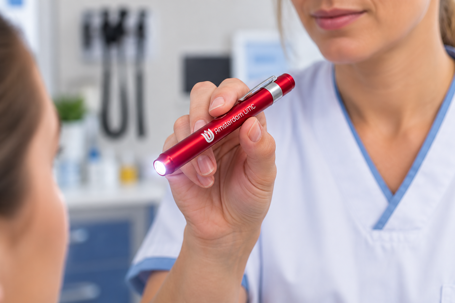 Red penlight held by a healthcare worker, ideal for examinations and assessments in clinical settings.